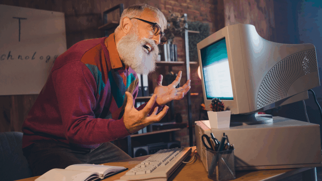 man yelling, frustrated at old computer